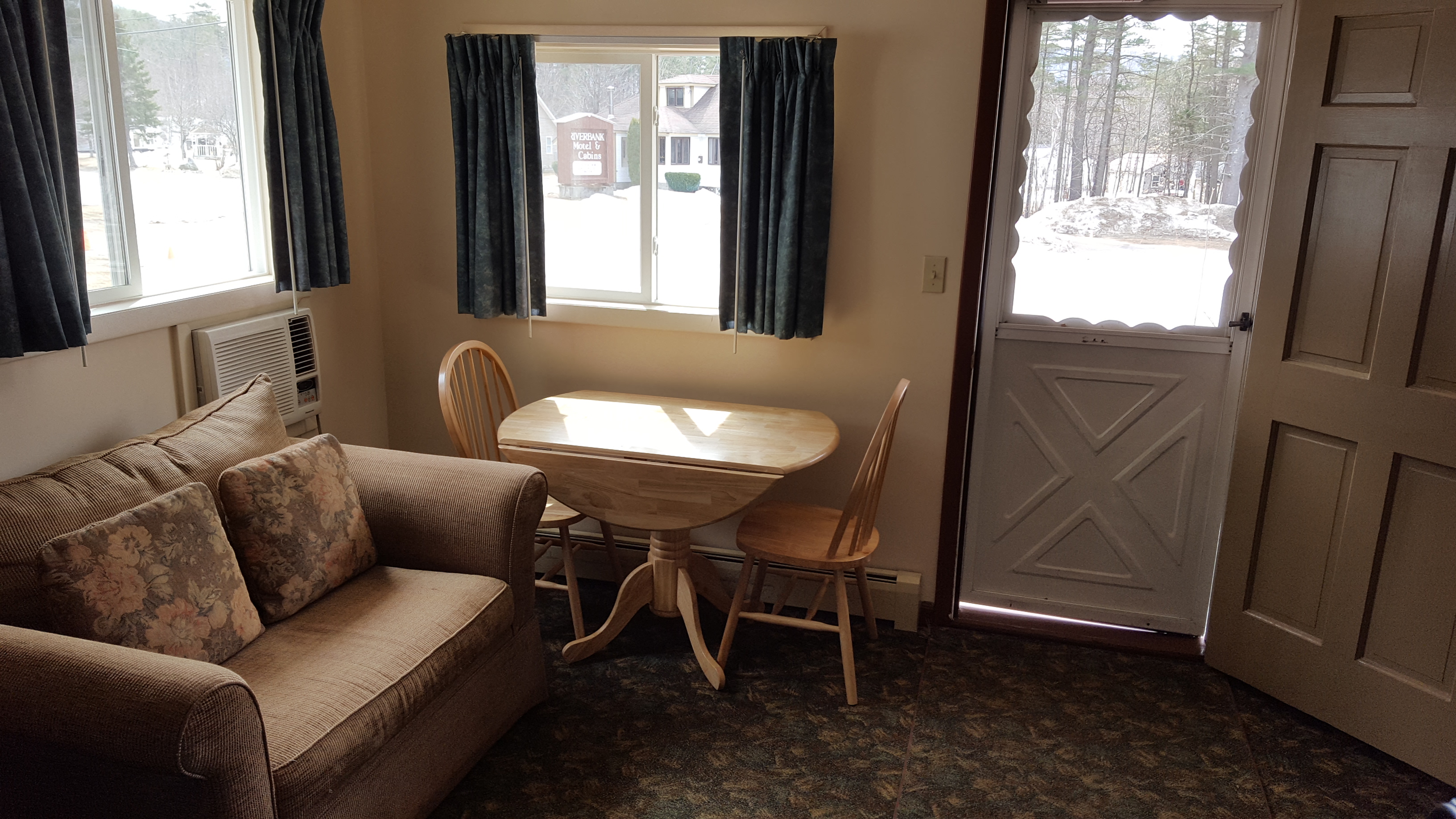 Motel room 2 dining table, loveseat and front door.