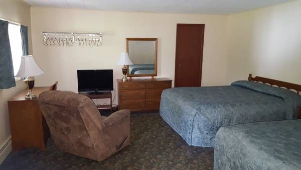 Motel room with two beds and recliner.