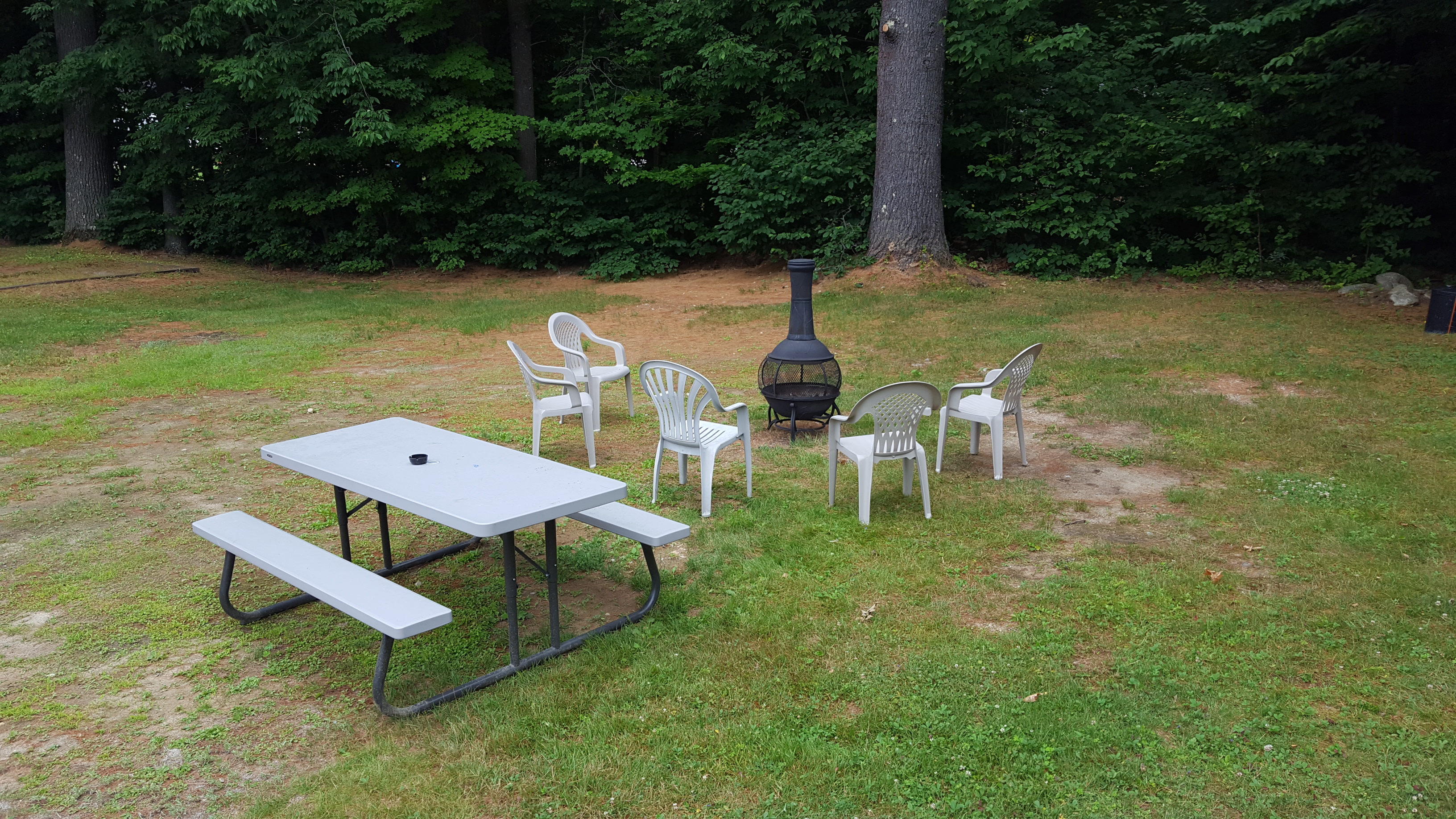 Picnic table and patio chairs around a wood stove
