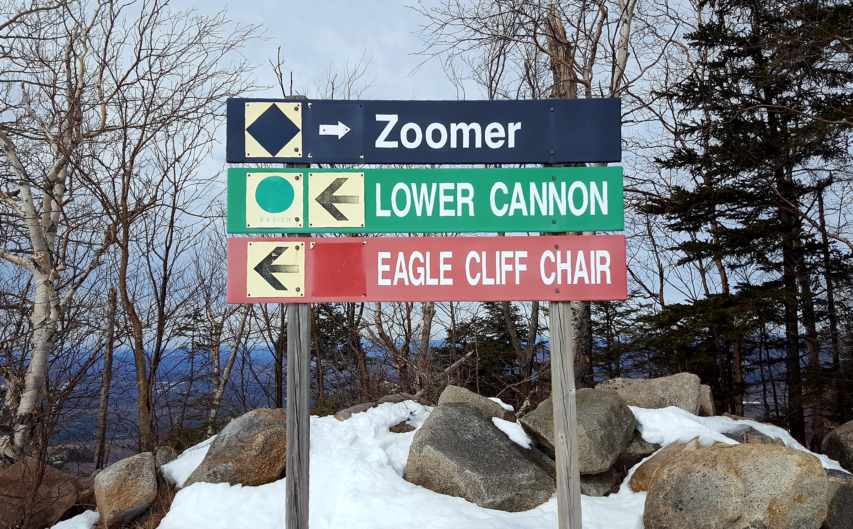 Ski trail signs. Text: Zoomer, Lower Cannon, Eagle Cliff Chair.